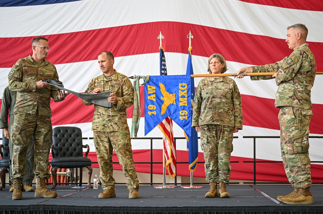 U.S. Air Force Airmen assigned to the 19th Airlift Wing encase the 19th Maintenance Group guidon during an inactivation ceremony at Little Rock Air Force Base, Arkansas, Sept. 18, 2025. The 19th Aircraft Maintenance Squadron and 19th Maintenance Squadron were officially reassigned to the 19th AW.