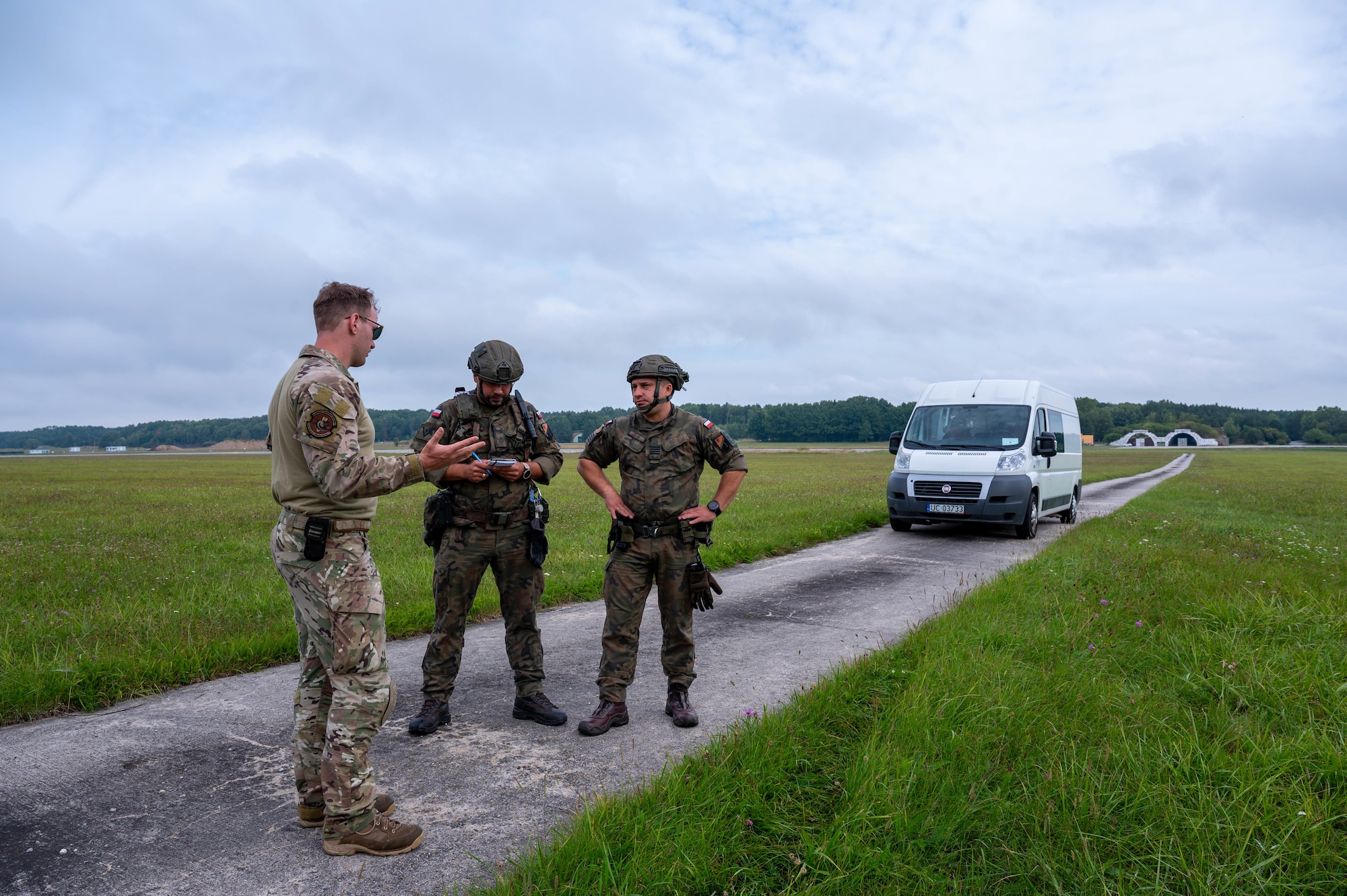An Airman speaks with two members of the Polish Armed Forces