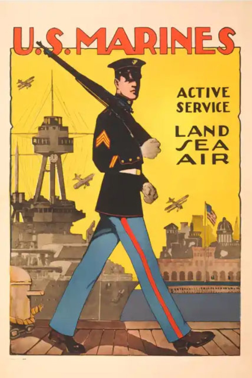 A Marine in dress uniform marching on a dock, with a battleship and city skyline visible in the background.