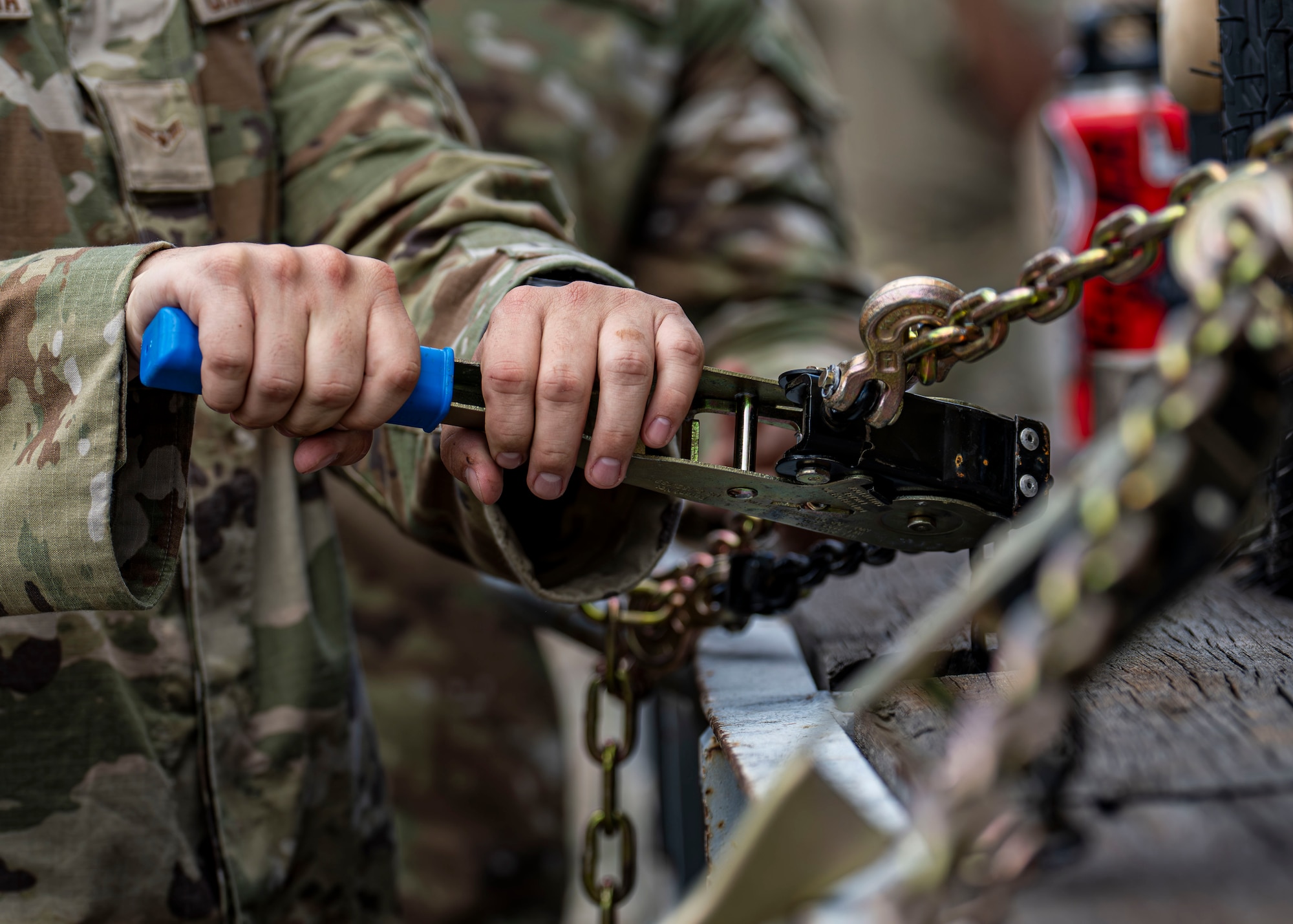 A U.S. Airman assigned to the 1st Special Operations Wing tightens a chain to secure equipment during Mission Ready Airmen Training
