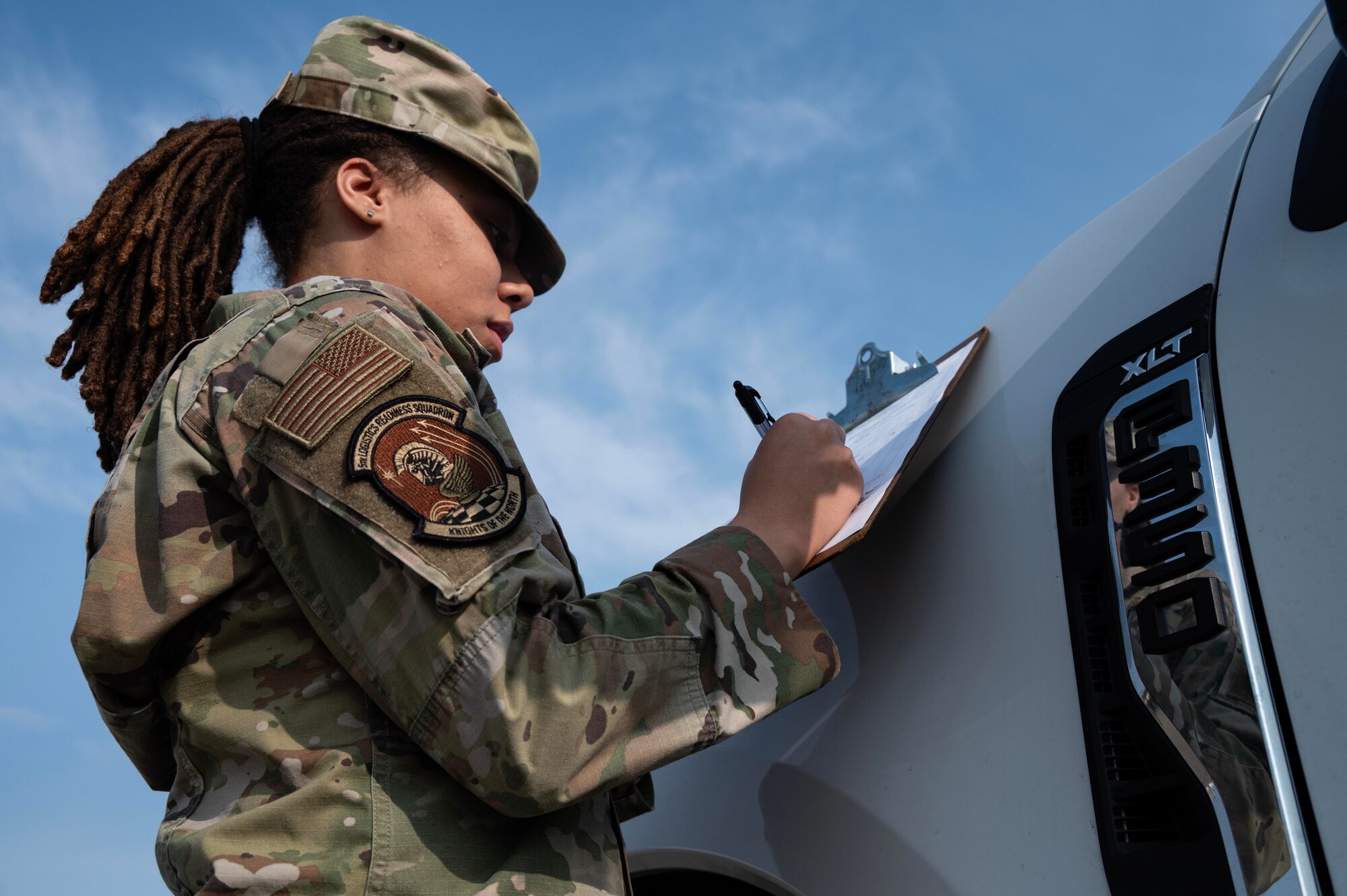 Airman 1st Class Zavia Eason, 5th Logistics Readiness Squadron V-flight fleet management and analysis specialist, signs a delivery sheet after receiving a shipment of up-armored Ford F-350s at Minot Air Force Base, North Dakota, Sept. 8, 2025. Over the course of the next two years, the installation will receive these vehicles as part of the gradual replacement of Bearcats and Humvees. (U.S. Air Force photo by Senior Airman Alyssa Bankston)
