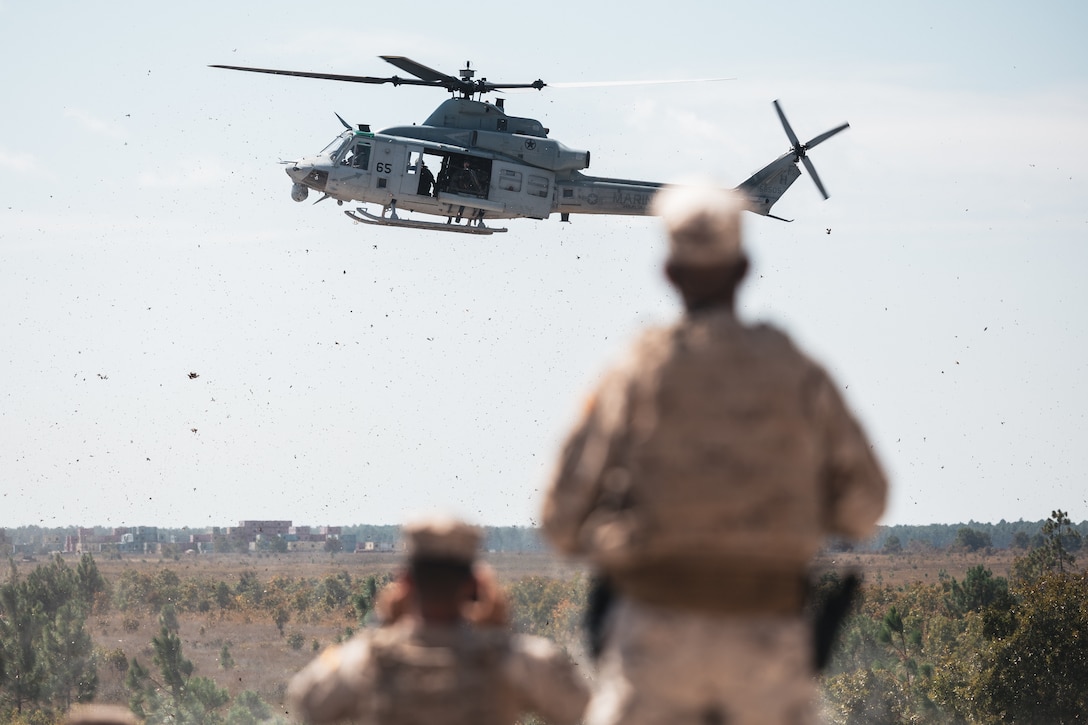A U.S. Marine Corps UH-1Y Venom helicopter with Marine Light Attack Helicopter Squadron (HMLA) 269, Marine Aircraft Group 29, 2nd Marine Aircraft Wing, flies over marines with Infantería de Marina (Spanish marine corps) while conducting close air support training for exercise UNITAS 2025 at Marine Corps Base Camp Lejeune, North Carolina, Sept. 17, 2025. UNITAS, which is Latin for “unity,” was conceived in 1959 and has taken place annually since first conducted in 1960. This year marks the 66th iteration of the world’s longest running annual multinational maritime exercise. The exercise trains forces in joint maritime operations that enhance tactical proficiency and increase interoperability with the presence of unmanned air, surface and submarine systems. (U.S. Marine Corps  photo by Sgt. Jorge Borjas)