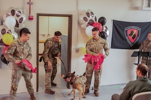 U.S. Air Force Senior Airman Drake Sherman, left, Staff Sgt. Alex Petkovic, middle, and Senior Airman Stone Miller, right, 354th Security Forces Squadron Military Working Dog handlers, cut the ceremonial ribbon for the newly renovated facility during a K9 kennel ribbon cutting ceremony at Eielson Air Force Base, Alaska, Sept. 12, 2025.
