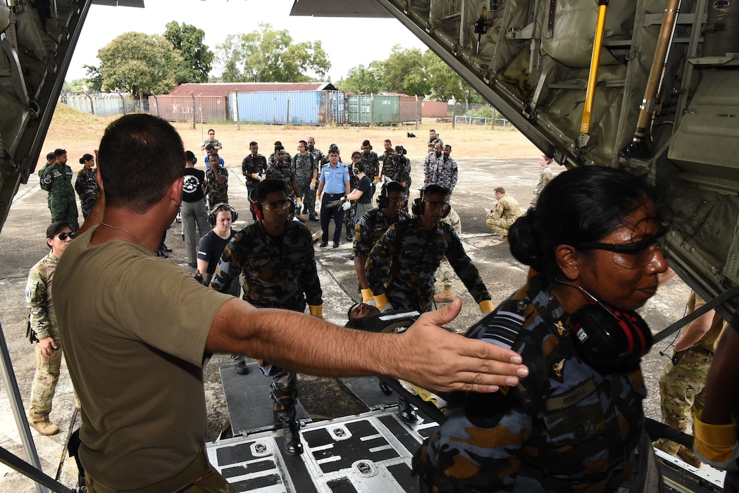 U.S. Air Force Maj. David Madrid, 18th Aeromedical Evacuation Squadron flight nurse instructor, directs Sri Lanka Air Force members carrying a litter with a simulated patient onto a C-130 Hercules during a Pacific Angel 25-1 mass casualty exercise at Katunayake Air Base, Sri Lanka, Sept. 11, 2025.