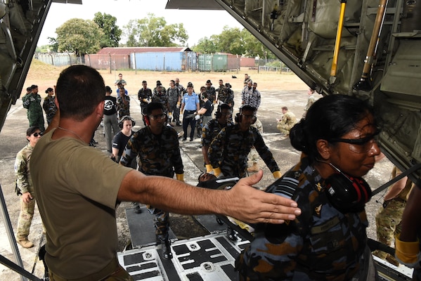 U.S. Air Force Maj. David Madrid, 18th Aeromedical Evacuation Squadron flight nurse instructor, directs Sri Lanka Air Force members carrying a litter with a simulated patient onto a C-130 Hercules during a Pacific Angel 25-1 mass casualty exercise at Katunayake Air Base, Sri Lanka, Sept. 11, 2025.