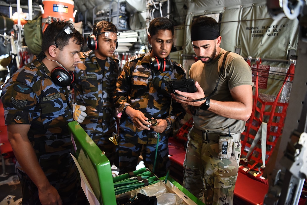 U.S. Air Force Tech. Sgt. Marcus Gomes, 18th Aeromedical Evacuation Squadron technician, reads medical equipment instructions to Sri Lanka Air Force members during a Pacific Angel 25-1 mass casualty exercise at Katunayake Air Base, Sri Lanka, Sept. 11, 2025.
