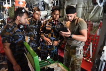 U.S. Air Force Tech. Sgt. Marcus Gomes, 18th Aeromedical Evacuation Squadron technician, reads medical equipment instructions to Sri Lanka Air Force members during a Pacific Angel 25-1 mass casualty exercise at Katunayake Air Base, Sri Lanka, Sept. 11, 2025.