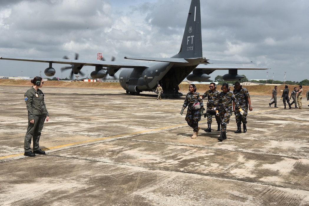 Sri Lanka Air Force members carry a litter with a simulated patient from a C-130 Hercules as Royal Australian Air Force Corporal Georgia Smith, left, Joint Health Command medical technician, evaluates during a Pacific Angel 25-1 mass casualty exercise at Katunayake Air Base, Sri Lanka, Sept. 11, 2025.