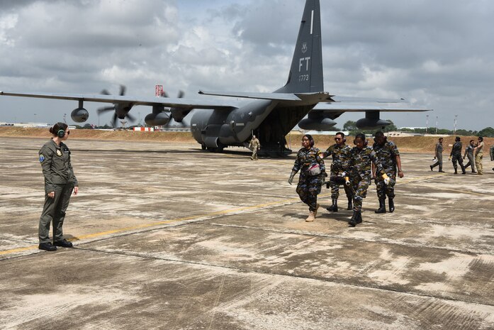 Sri Lanka Air Force members carry a litter with a simulated patient from a C-130 Hercules as Royal Australian Air Force Corporal Georgia Smith, left, Joint Health Command medical technician, evaluates during a Pacific Angel 25-1 mass casualty exercise at Katunayake Air Base, Sri Lanka, Sept. 11, 2025.