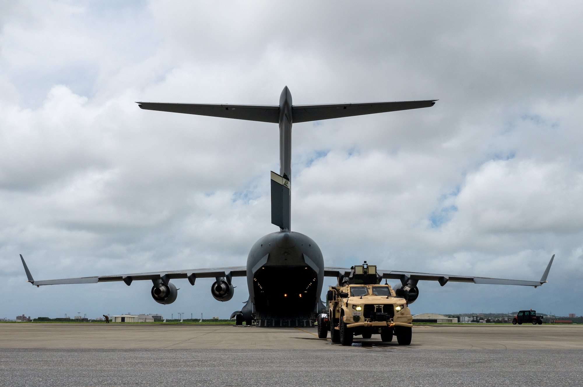 A tactical vehicle is backing into an aircraft.