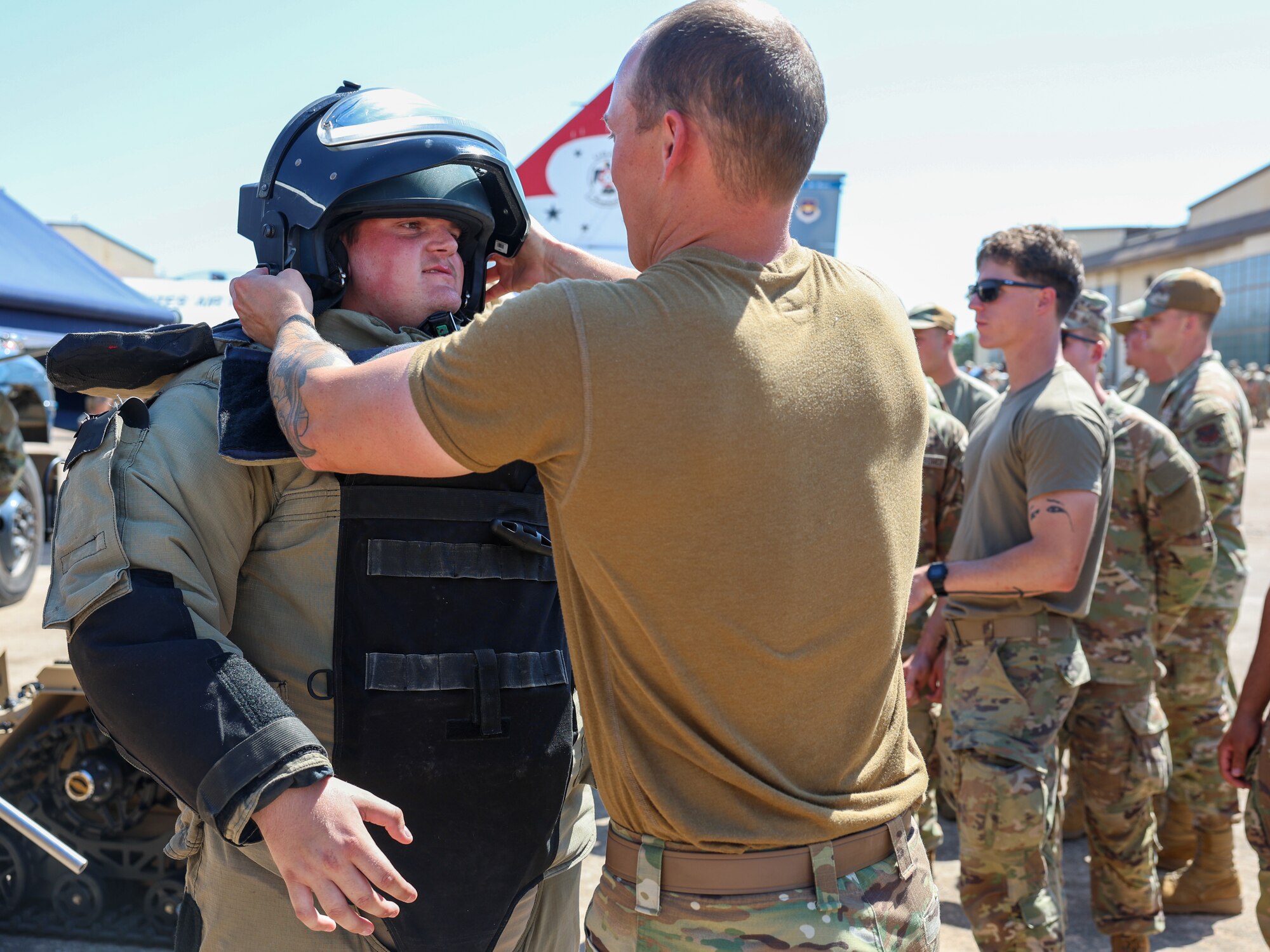 U.S. Air Force Tech Sgt. Ashton Flynt, 336 Training Squadron explosive ordinance disposal instructor, fits an EOD Bomb Suit helmet onto a Pioneer Technology student during a Bracer Forge exercise at Sheppard Air Force Base, Texas, Sept. 11, 2025.
