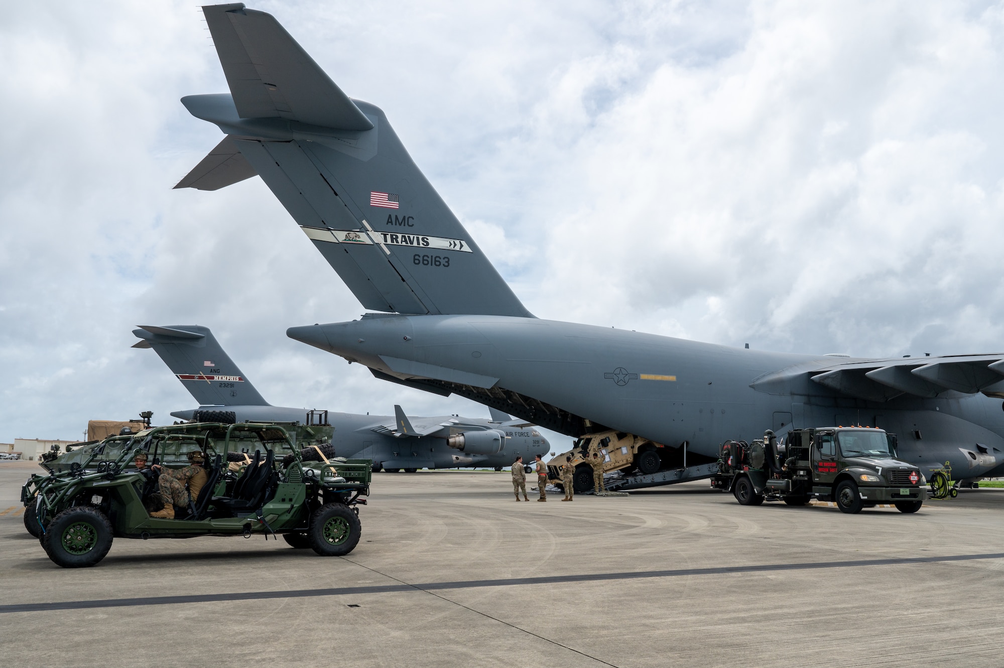 Military vehicles are being moved into an aircraft.