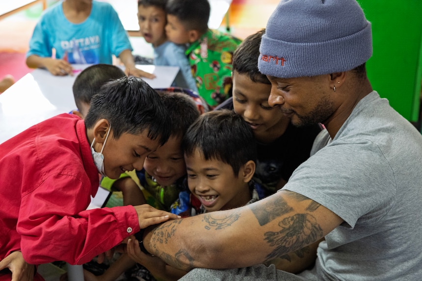Civilian mariner Joshua Harris, deckhand, assigned to Lewis and Clark-class dry cargo ship USNS Amelia Earhart (T-AKE 6), interacts with children of the Fountain of Life Children’s Center in Pattaya, Thailand, during a community outreach event, Sept. 10.