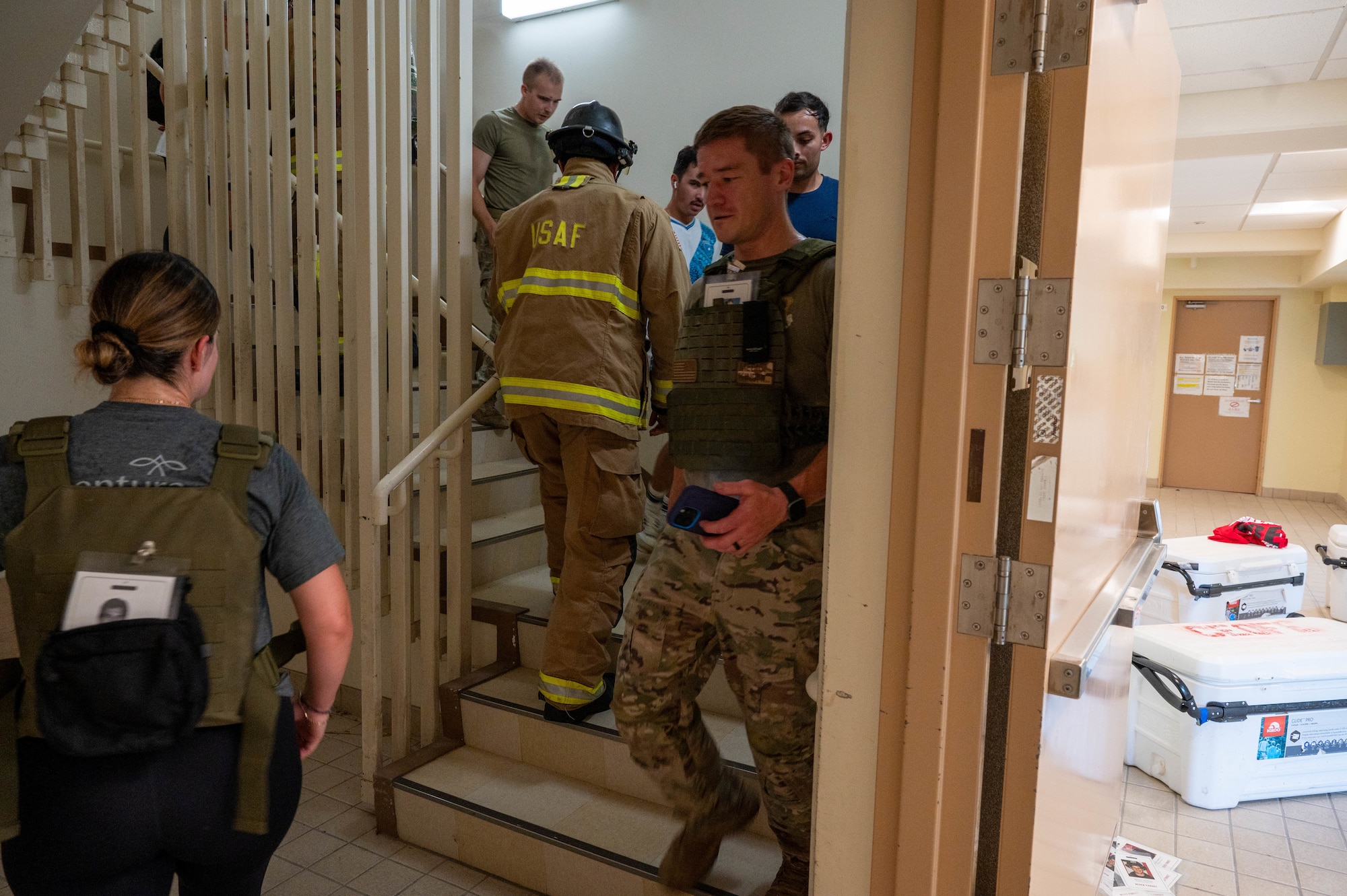 Service members and civilians climbing stairs.
