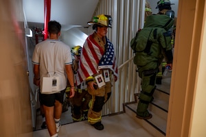 Service members and civilians climbing stairs.