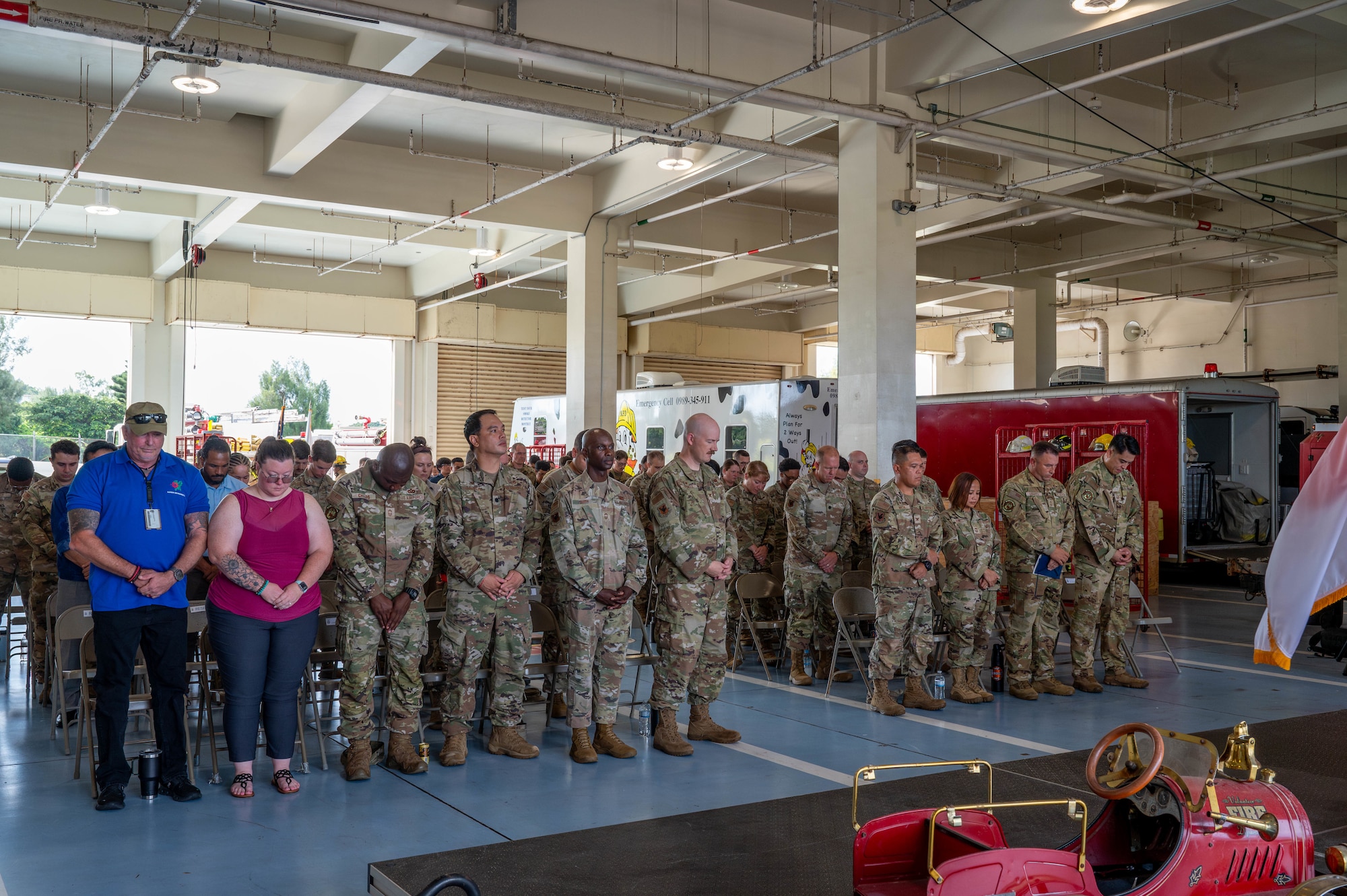Service members bow their heads during a moment of silence.
