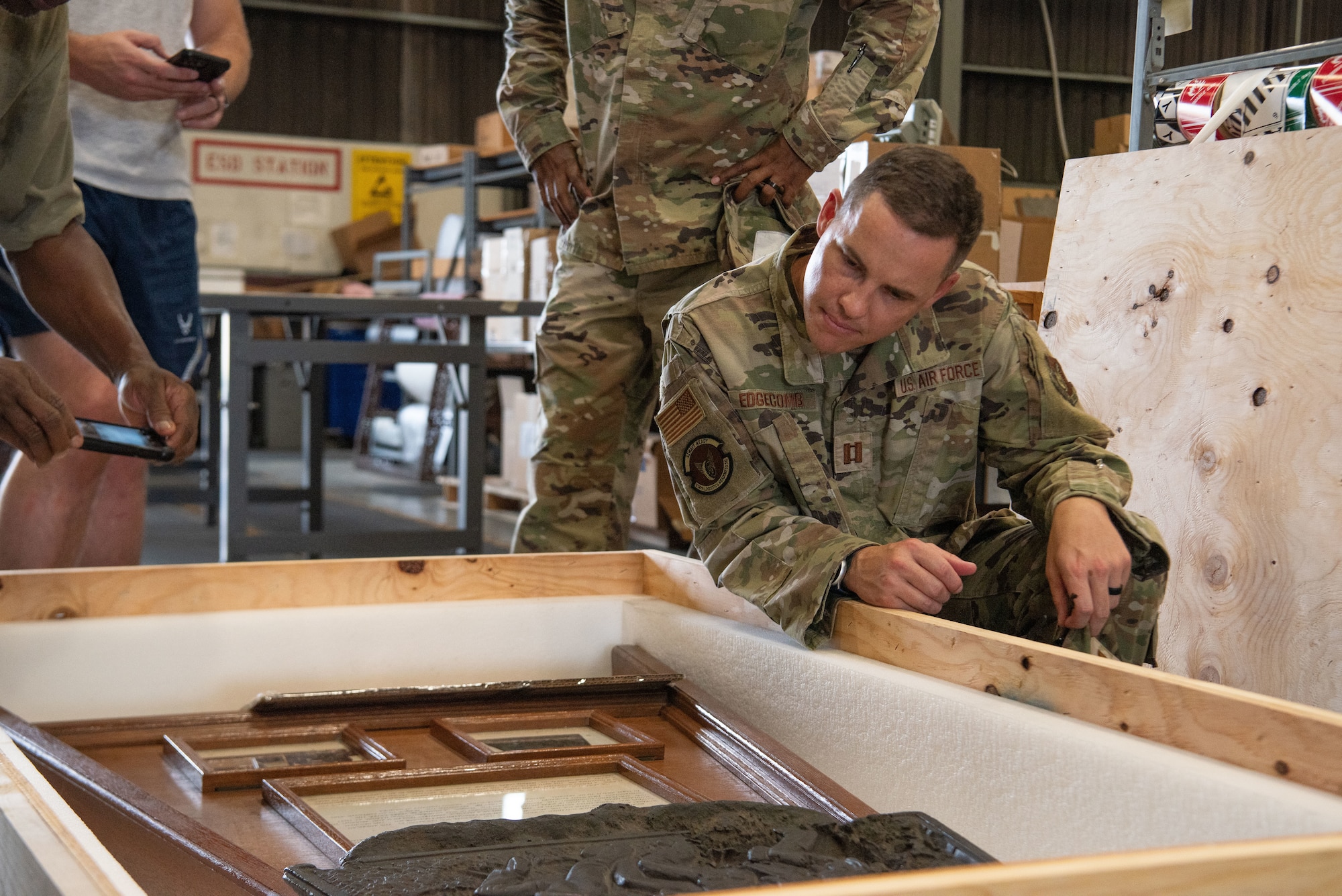 A servicemember looks into a crate