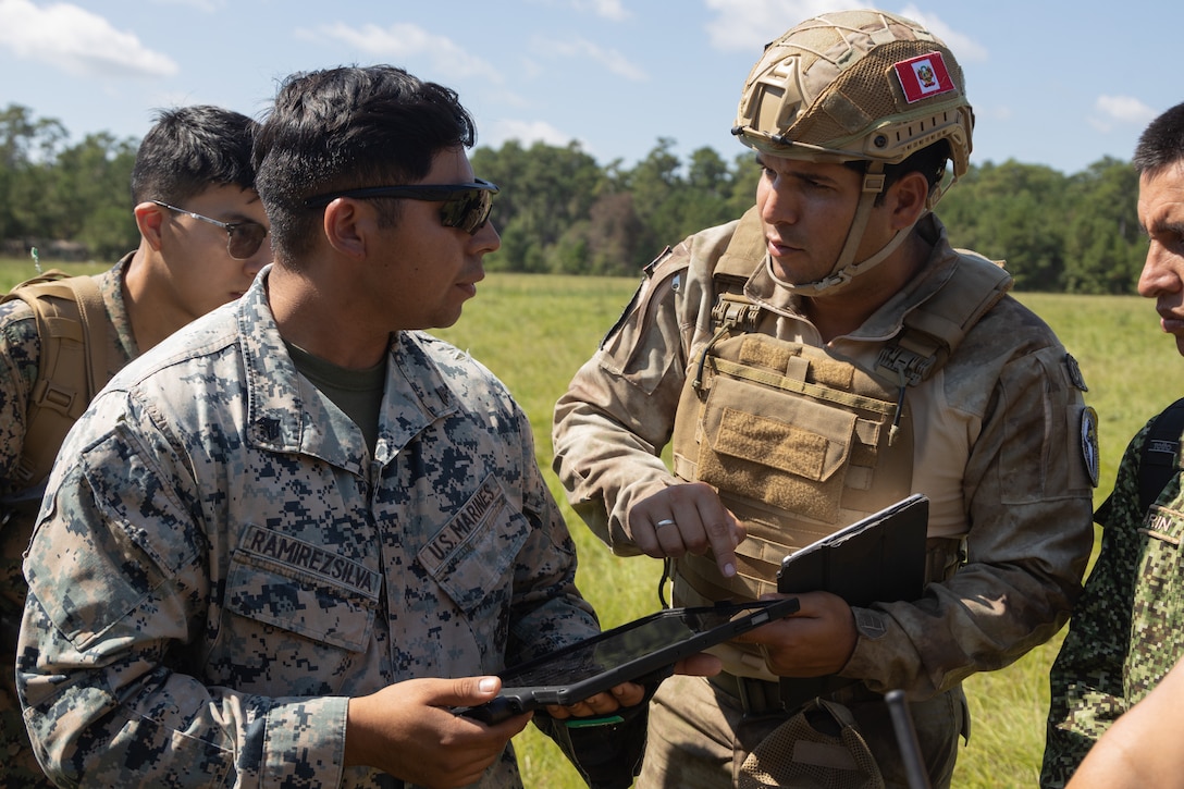 U.S. Marine Corps Cpl. Adam Ramirezsilva, a distribution management specialist with Combat Logistics Battalion 22, Combat Logistics Regiment 27, 2nd Marine Logistics Group, briefs a Peruvian Infantería de Marina del Perú (Peruvian naval infantry) on the Tactical Resupply Vehicle 150 unmanned aircraft system during exercise UNITAS 2025 at Marine Corps Base Camp Lejeune, North Carolina, Sept. 17, 2025. UNITAS, which is Latin for “unity,” was conceived in 1959 and has taken place annually since first conducted in 1960. This year marks the 66th iteration of the world’s longest running annual multinational maritime exercise. The exercise trains forces in joint maritime operations that enhance tactical proficiency and increase interoperability with the presence of unmanned air, surface and submarine systems. (U.S. Marine Corps photo by Lance Cpl. Franco Lewis)