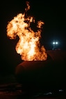 An aircraft fire training facility burns during a live fire exercise at Minot Air Force Base, North Dakota, Sept. 16, 2025. Live burn training keeps firefighters prepared and provides them with a realistic fire experience before responding to an emergency. (U.S. Air Force photo by Senior Airman Alyssa Bankston)