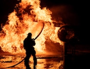 5th Civil Engineer Squadron fire protection specialists extinguish an ongoing fire during a live aircraft fire exercise at Minot Air Force Base, North Dakota, Sept. 16, 2025. A fire hose's typical operating pressure ranges from 116 to 290 pounds per square inch. (U.S. Air Force photo by Senior Airman Alyssa Bankston)