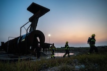 The 5th Civil Engineer Squadron’s fire protection team exits an aircraft fire training facility before a live structure fire exercise at Minot Air Force Base, North Dakota, Sept. 16, 2025. Military firefighters protect the environment, people and property against fires and disasters. (U.S. Air Force photo by Senior Airman Alyssa Bankston)