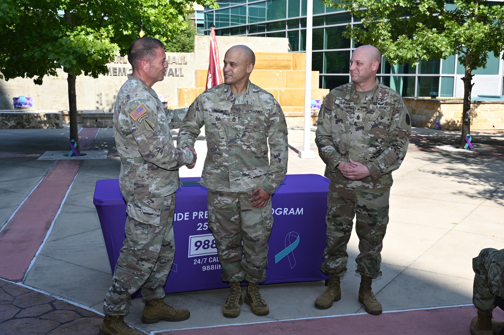 Col. Mark Jacques, CRDAMC commander, presents a challenge coin to Sgt. 1st Class Etiel Sanchez, People Directorate NCOIC, during the 2025 Suicide Prevention Month proclamation ceremony at Carl R. Darnall Army Medical Center on Sept. 18.