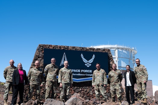  Military members pose for a photo in front of the Maui Space Surveillance Complex sign.