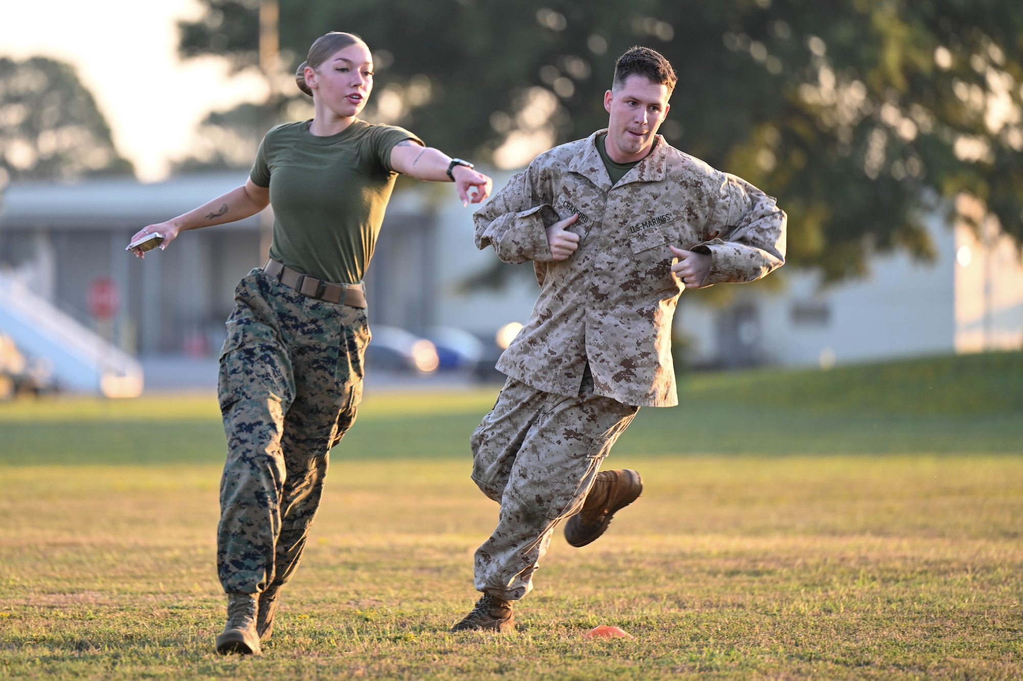 A man and woman run on a field.