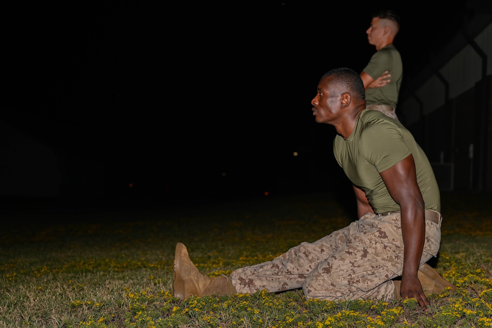 A man in uniform stretches on the ground.