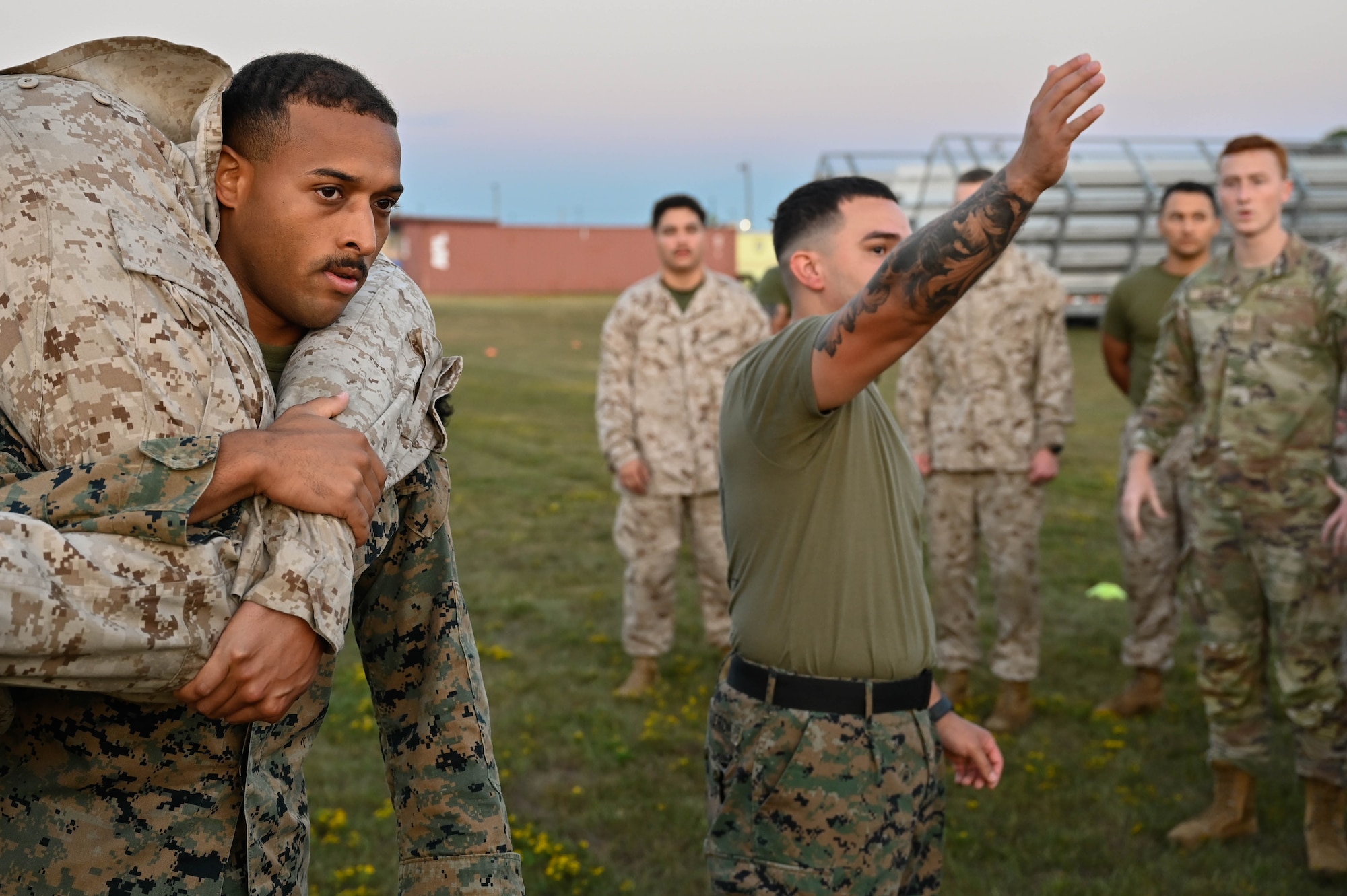 A group of people in uniform have a conversation on a field.