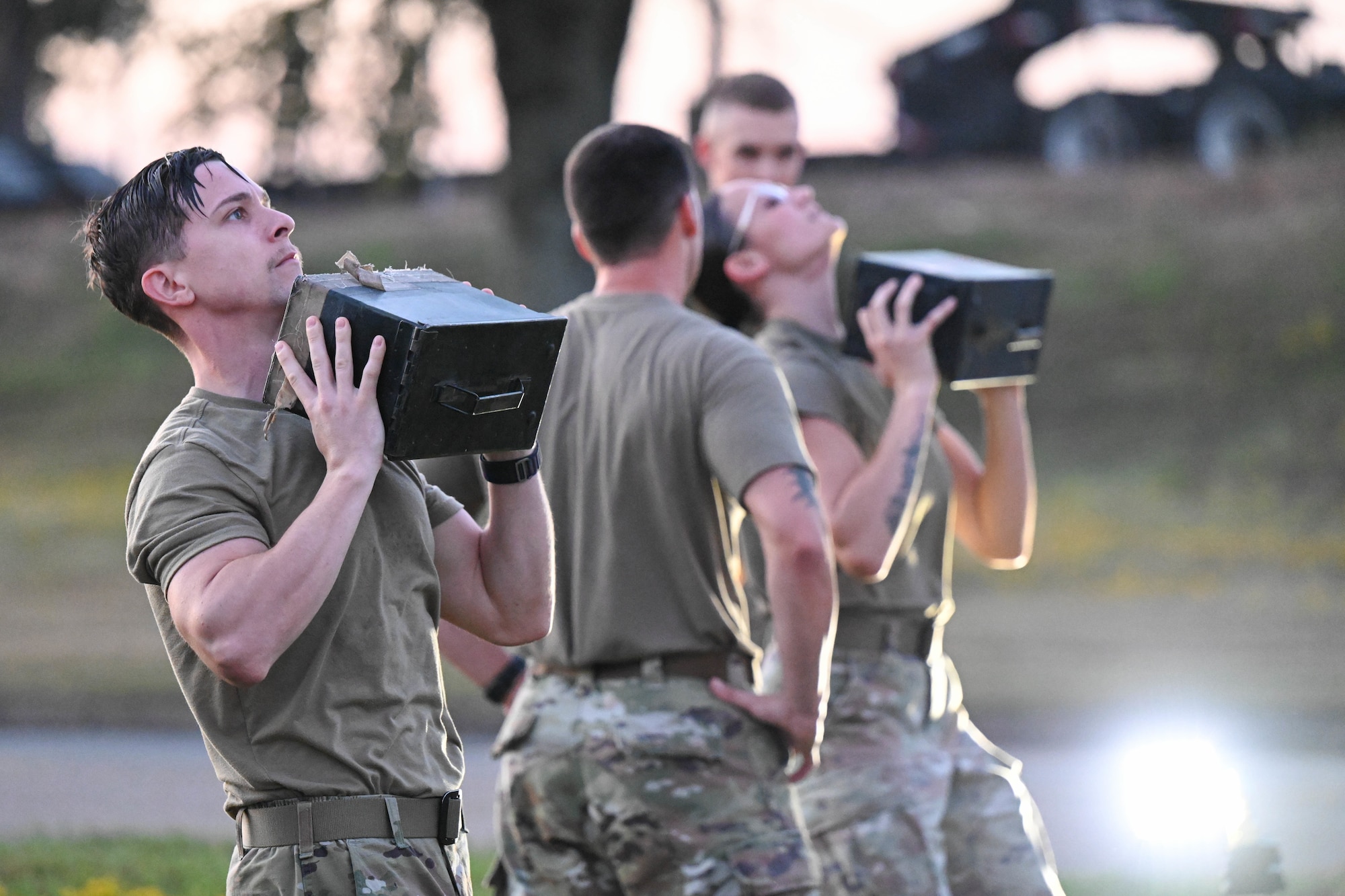 Men in uniform lift ammunition boxes.