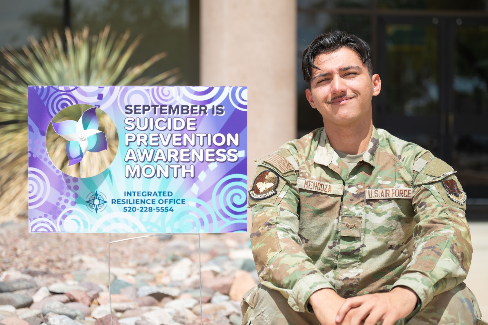 U.S. Air Force Airman 1st Class Antonio Mendoza, 355th Civil Engineer Squadron water and fuel systems technician, poses with a Suicide Prevention and Awareness Month sign at Davis-Monthan Air Force Base, Arizona, September 18, 2025. Mendoza is Applied Suicide Intervention Skills Training certified, enhancing his ability to help Airmen in times of crisis. (U.S. Air Force photo by Airman 1st Class Jaden Kidd)