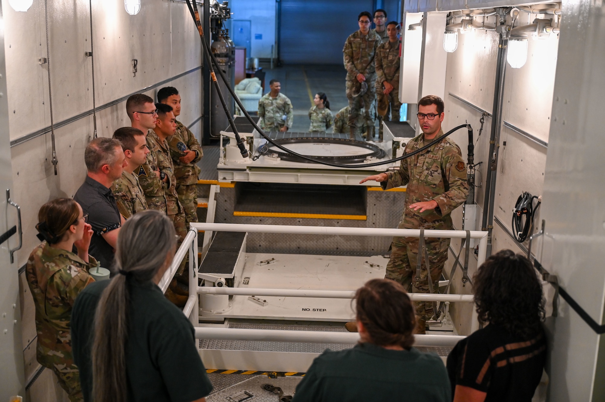 a group of people stand inside a semi trailer configured to transport a missile