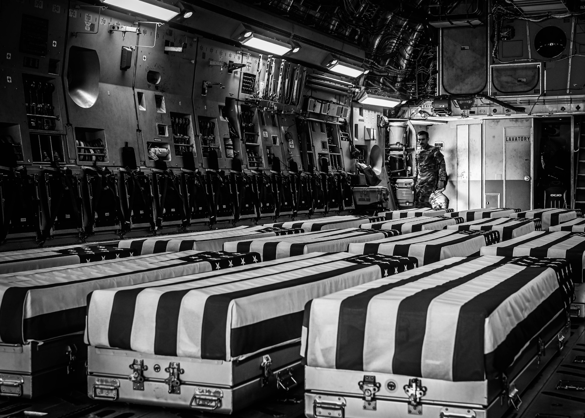 Caskets carrying the remains of unidentified service members from past conflicts await to be carried off a C-17 Globemaster III at Offutt Air Force Base, Neb., July 17, 2025. Service members who perform as pallbearers will carry the caskets one-by-one to an awaiting vehicle which will then transport them to the Defense POW/MIA Accounting Agency for analysis. (U.S. Air Force photo by Daniel Martinez)