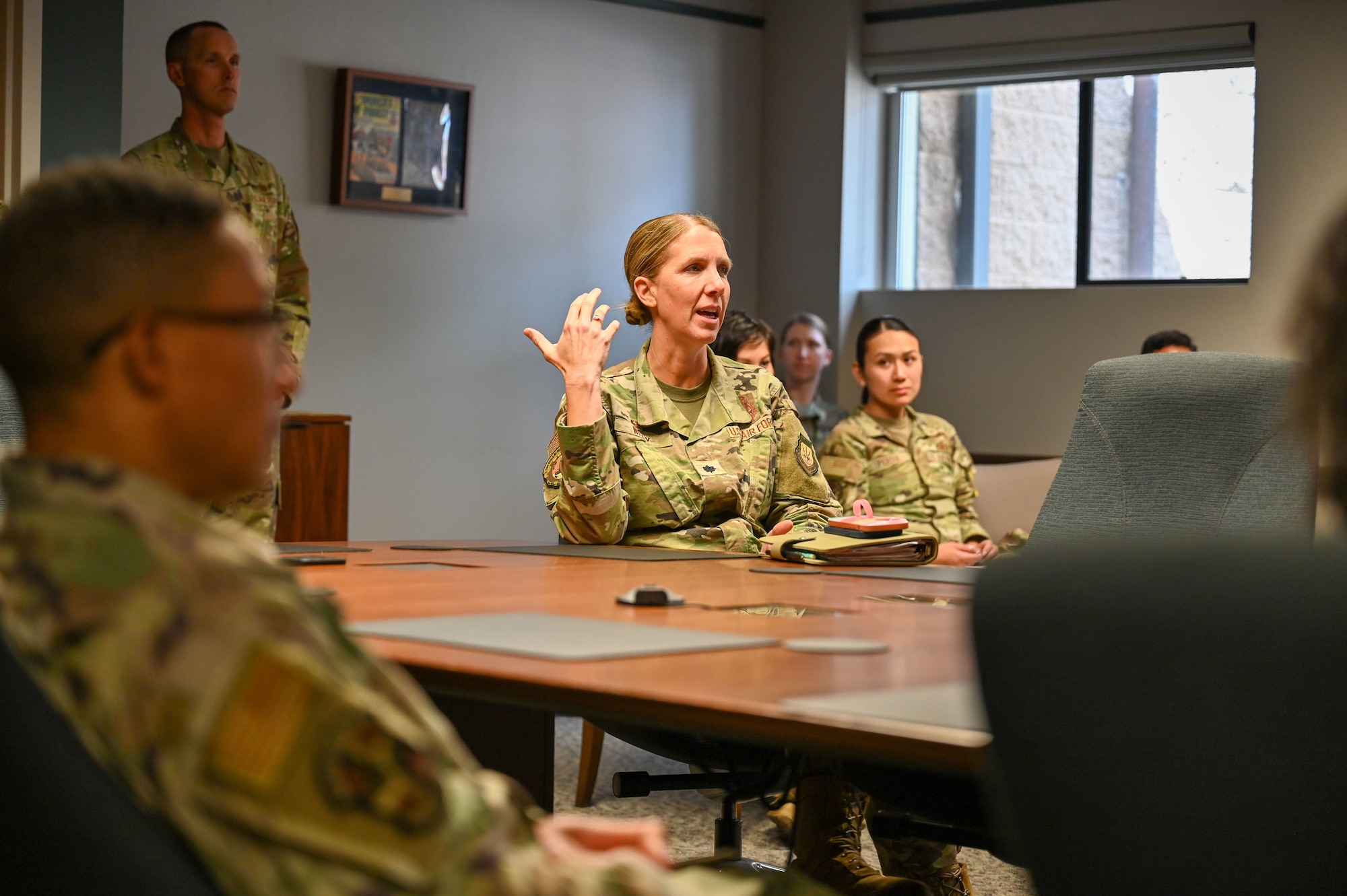 a person sits at a table and speaks to a group of people