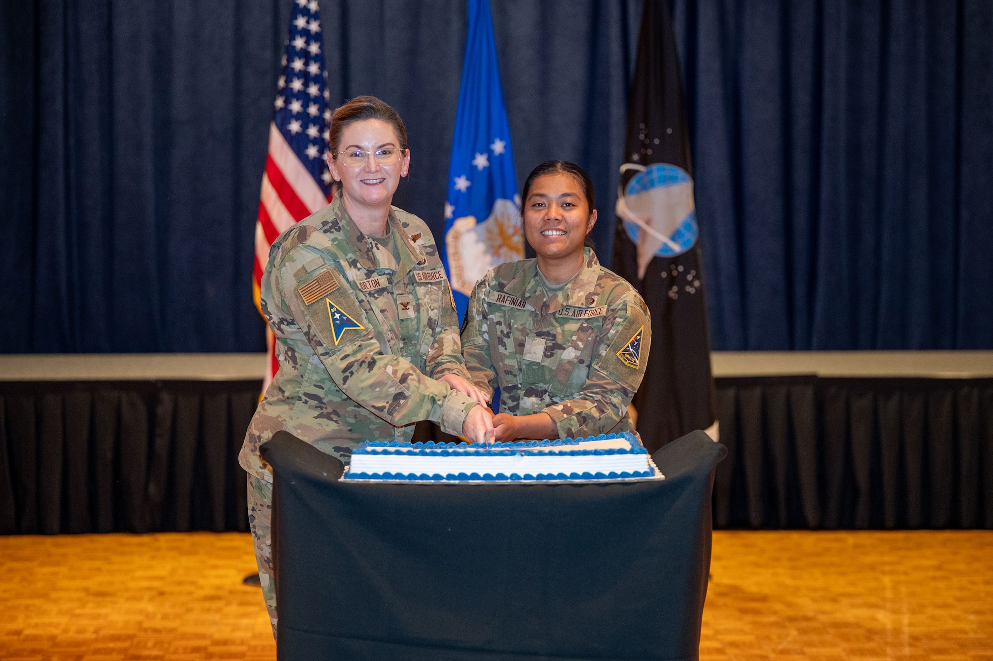 Two people cut a cake.
