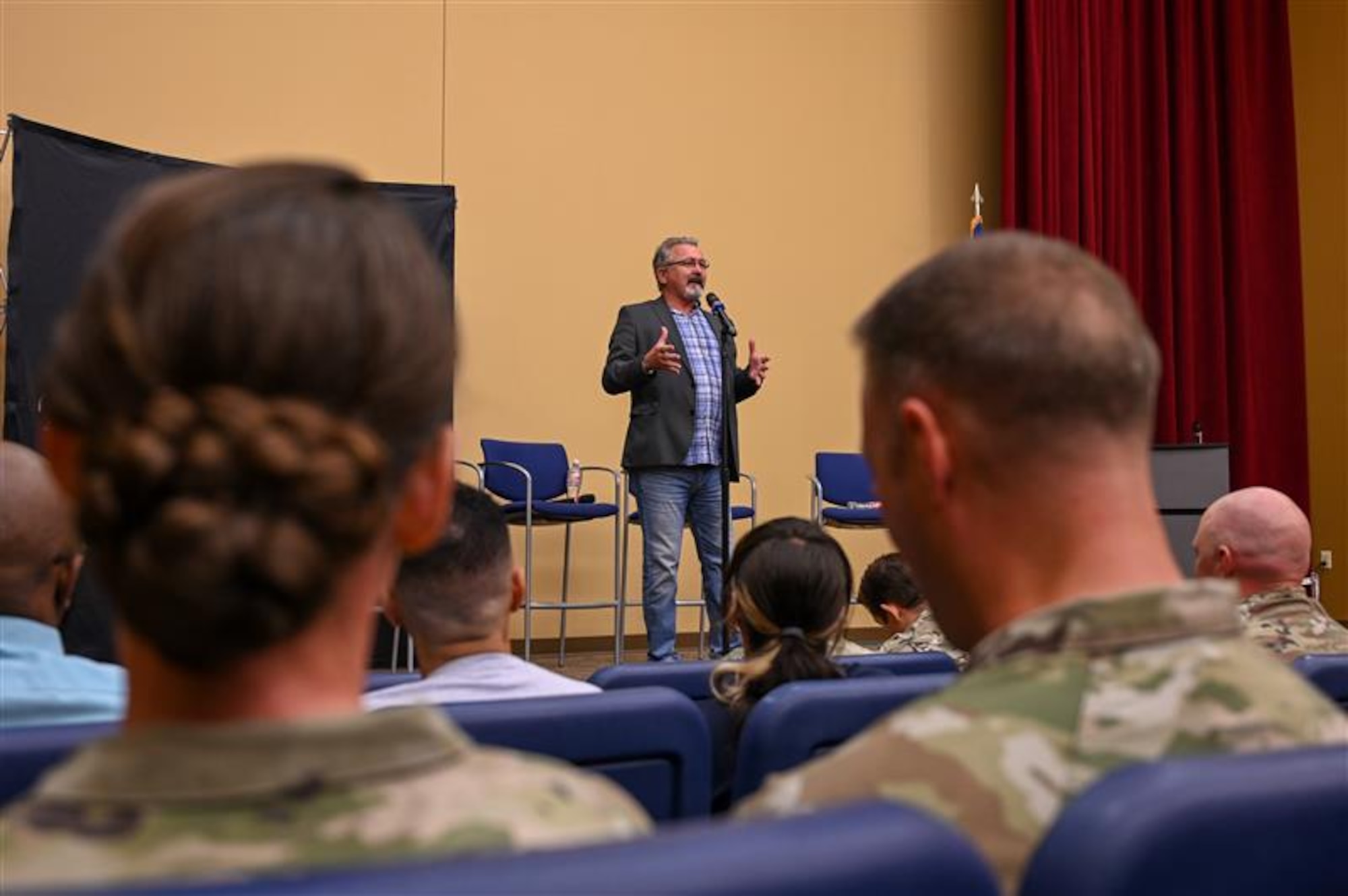 A man stands on stage and speaks to the audience