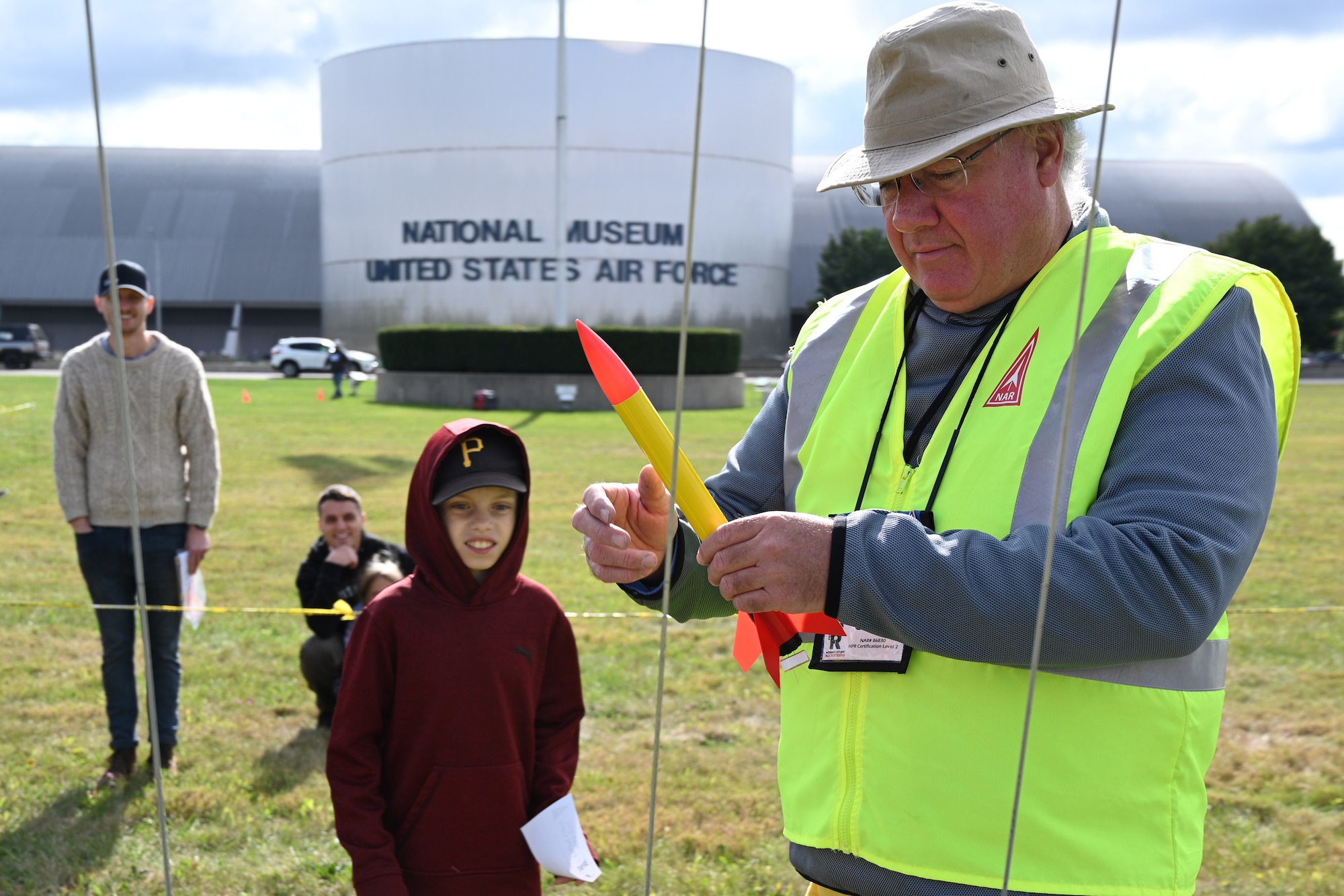 A volunteer helps a participant ready their rocket for launch on the front lawn of the National Museum of the U.S. Air Force.