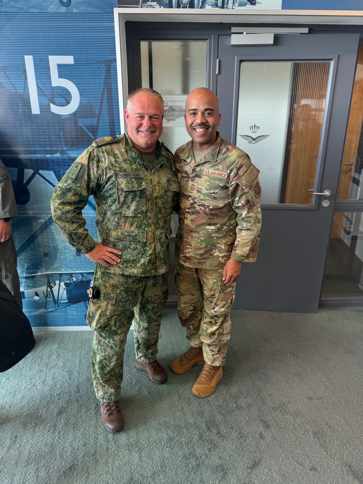 Two men stand next to each other and pose for a photo