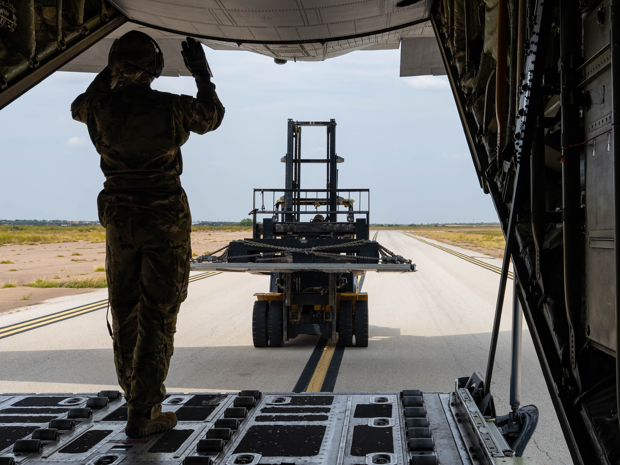 U.S. Air Force Staff Sgt. Kory Coronely-Yamamoto, 39th Airlift Squadron loadmaster, offloads a palette from a C-130J Super Hercules assigned to the 317th Airlift Wing, at Tye Landing Zone, Dyess Air Force Base, Texas, Aug. 26, 2025. Efficient cargo handling is critical for the 317th AW's ability to quickly deliver supplies and equipment to support global operations. (U.S. Air Force photo by Senior Airman Jade M. Caldwell)