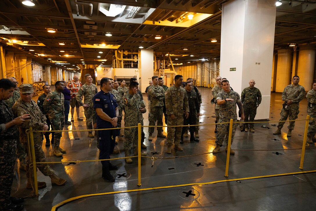 U.S. Marine Corps Chief Warrant Officer 3 Alexander Woodward, port operations officer in charge at Blount Island Command, explains cargo loading procedures Sept. 19, 2025, during a tour aboard the USNS Sgt. William W. Seay, a cargo ship operated by the U.S. Navy’s Military Sealift Command, at Marine Corps Support Facility Blount Island in Florida. The ship visit was part of a WHINSEC tour highlighting how the Marine Corps’ prepositioning programs support rapid global response. (U.S. Marine Corps photo by Dustin Senger)