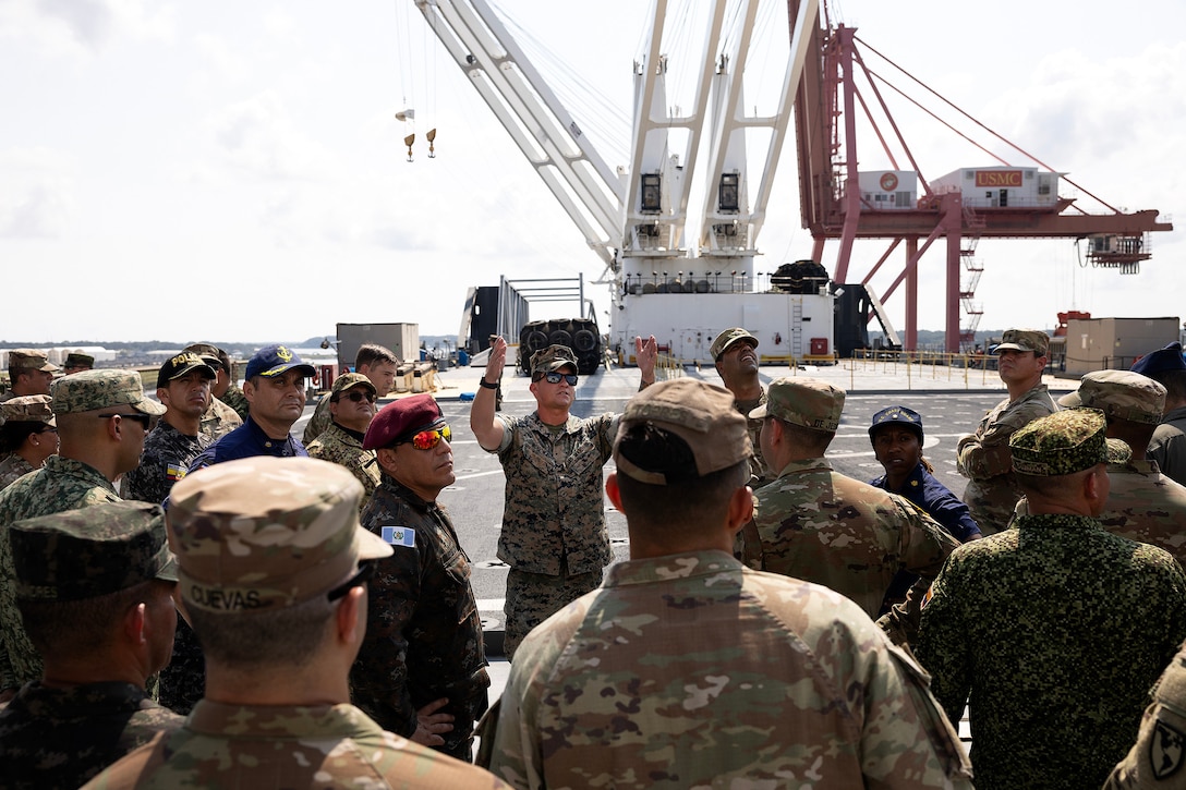 U.S. Marine Corps Chief Warrant Officer 3 Alexander Woodward, port operations officer in charge at Blount Island Command, explains cargo loading procedures Sept. 19, 2025, during a tour aboard the USNS Sgt. William W. Seay, a cargo ship operated by the U.S. Navy’s Military Sealift Command, at Marine Corps Support Facility Blount Island in Florida. The ship visit was part of a WHINSEC tour highlighting how the Marine Corps’ prepositioning programs support rapid global response. (U.S. Marine Corps photo by Dustin Senger)