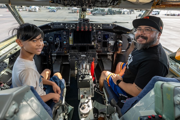 Community members inside the flight deck of an aircraft.