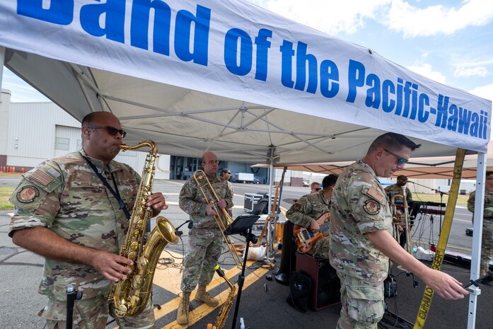 Band members play instruments in military uniform.