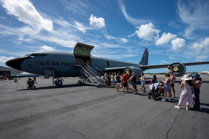 A line of people board an aircraft.