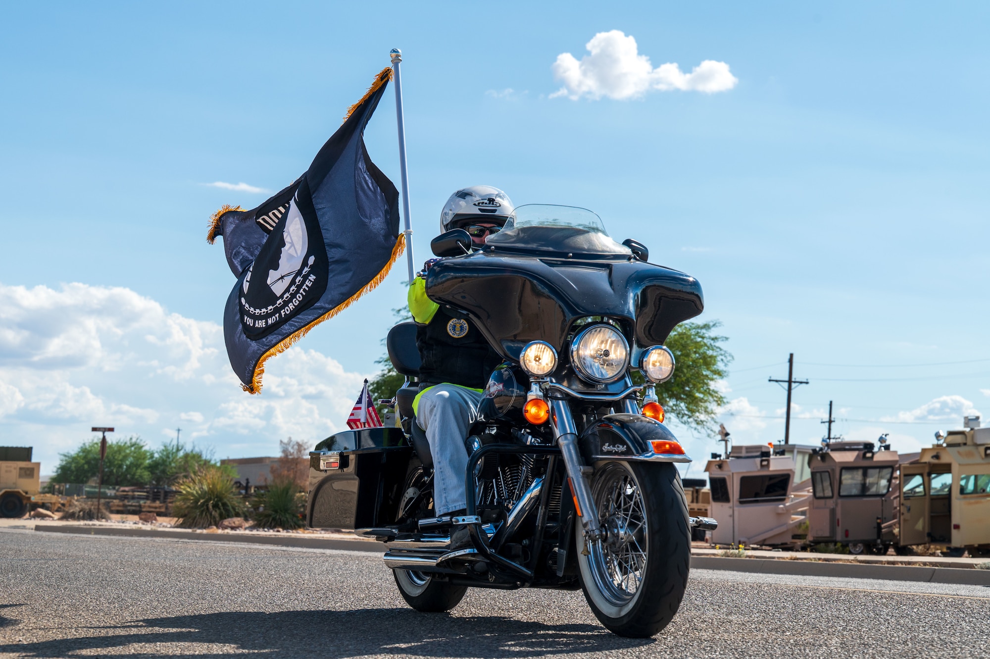 Robby Johnson, retired Airman, rides his motorcycle with the Prisoner of War and Missing in Action flag at Davis-Monthan Air Force Base, Arizona, Sept. 18, 2025. Johnson performed the first two laps of the 24-hour POW/MIA remembrance run. (U.S. Air Force photo by Senior Airman Jasmyne Bridgers-Matos)