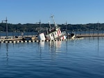 A tug begins to sink near in the Bremerton Marina, near Bremerton, Washington, Sept. 17, 2025, causing pollution.