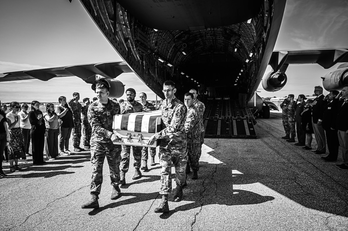 Military service members carry a casket off a C-17 Globemaster III with unidentified remains of U.S. service members during an Honorable Carry Ceremony at Offutt Air Force Base, Neb., July 17, 2025. The Defense POW/MIA Accounting Agency coordinates the ceremony to pay tribute to unidentified fallen service members from past conflicts. (U.S. Air Force photo by Daniel Martinez)