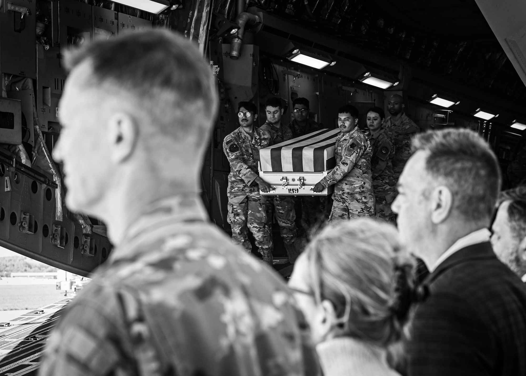 Service members make their way down the ramp of a C-17 Globemaster III while carrying the remains of an unidentified service member during an Honorable Carry Ceremony at Offutt Air Force Base, Neb., July 17, 2025. Formations of military and civilian personnel solemnly stand by to pay their respects to the fallen. (U.S. Air Force photo by Daniel Martinez)