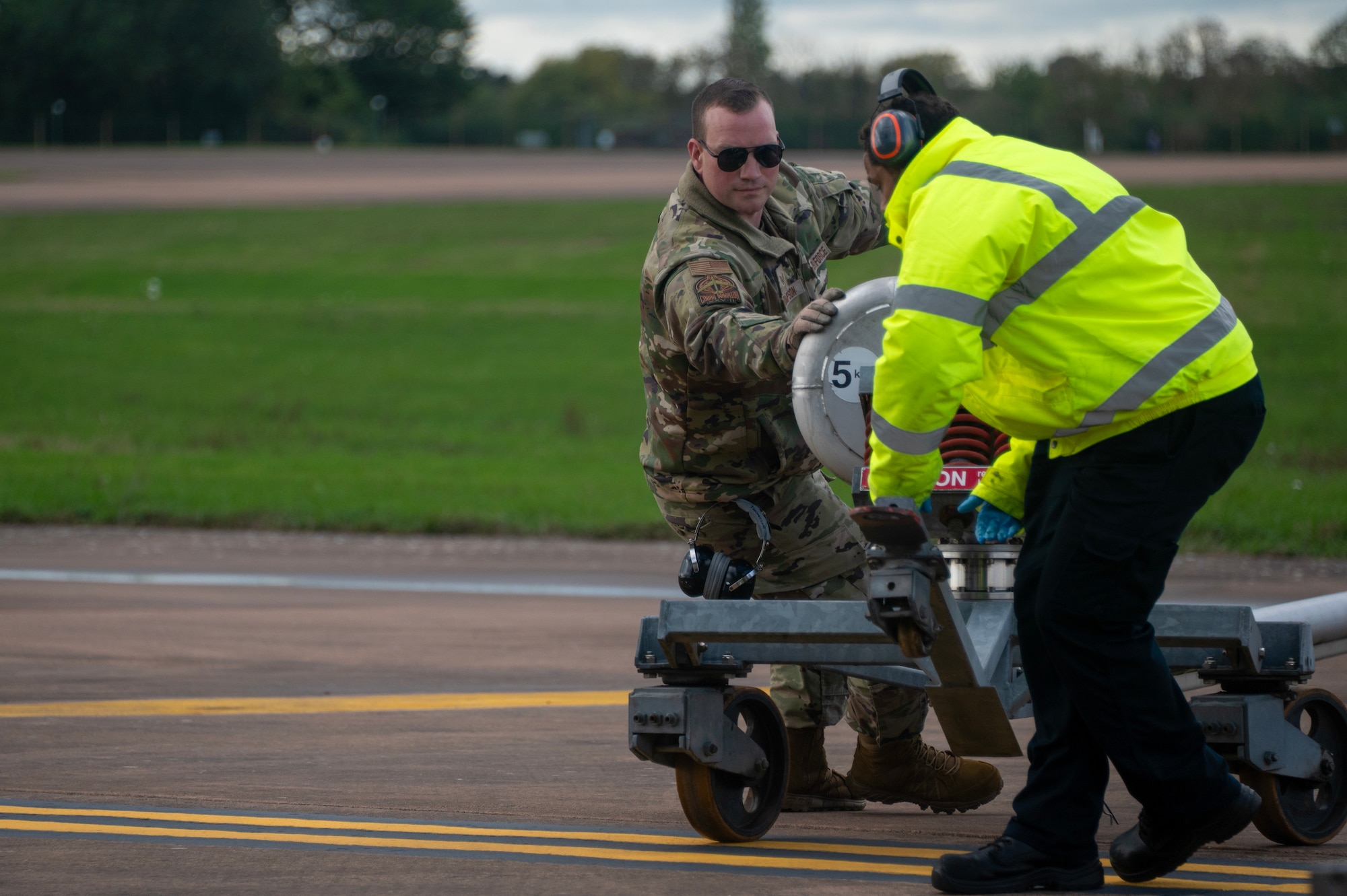 U.S. Air Force Staff Sgt. Mark Thompson, a fuels systems specialist assigned to Westover Air Reserve Base, Massachusetts, augments the 307th Bomb Wing, from Barksdale Air Force Base, Louisiana,  and positions refueling equipment during Exercise Cobra Warrior 25-2 at RAF Fairford, England, Sept. 18, 2025. The exercise provides U.S. forces an opportunity to train alongside NATO Allies and partners in a complex, multinational environment. (U.S. Air Force photo by Staff Sgt. Tambri Cason)